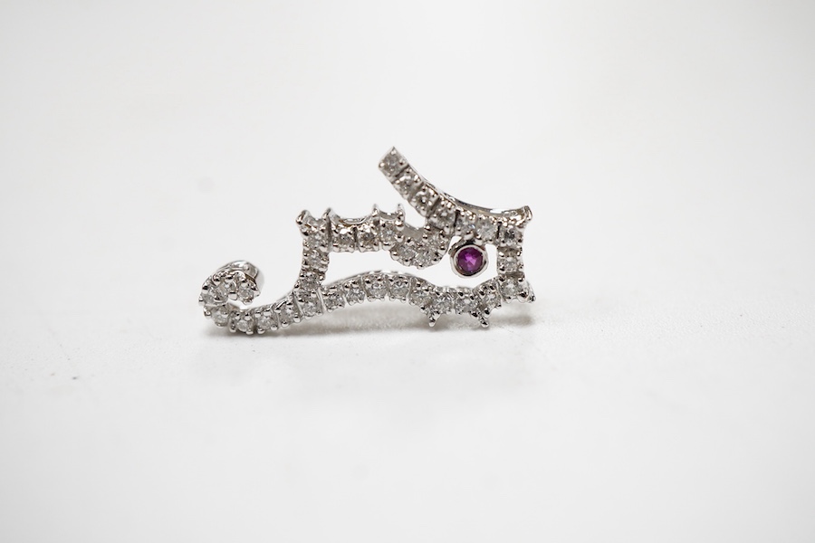 A recent 18k white metal diamond cluster set seahorse charm/pendant, with single stone ruby set eye, 19mm.
